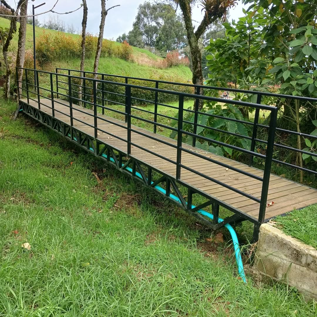 Puente peatonal en madera y estructura metálica