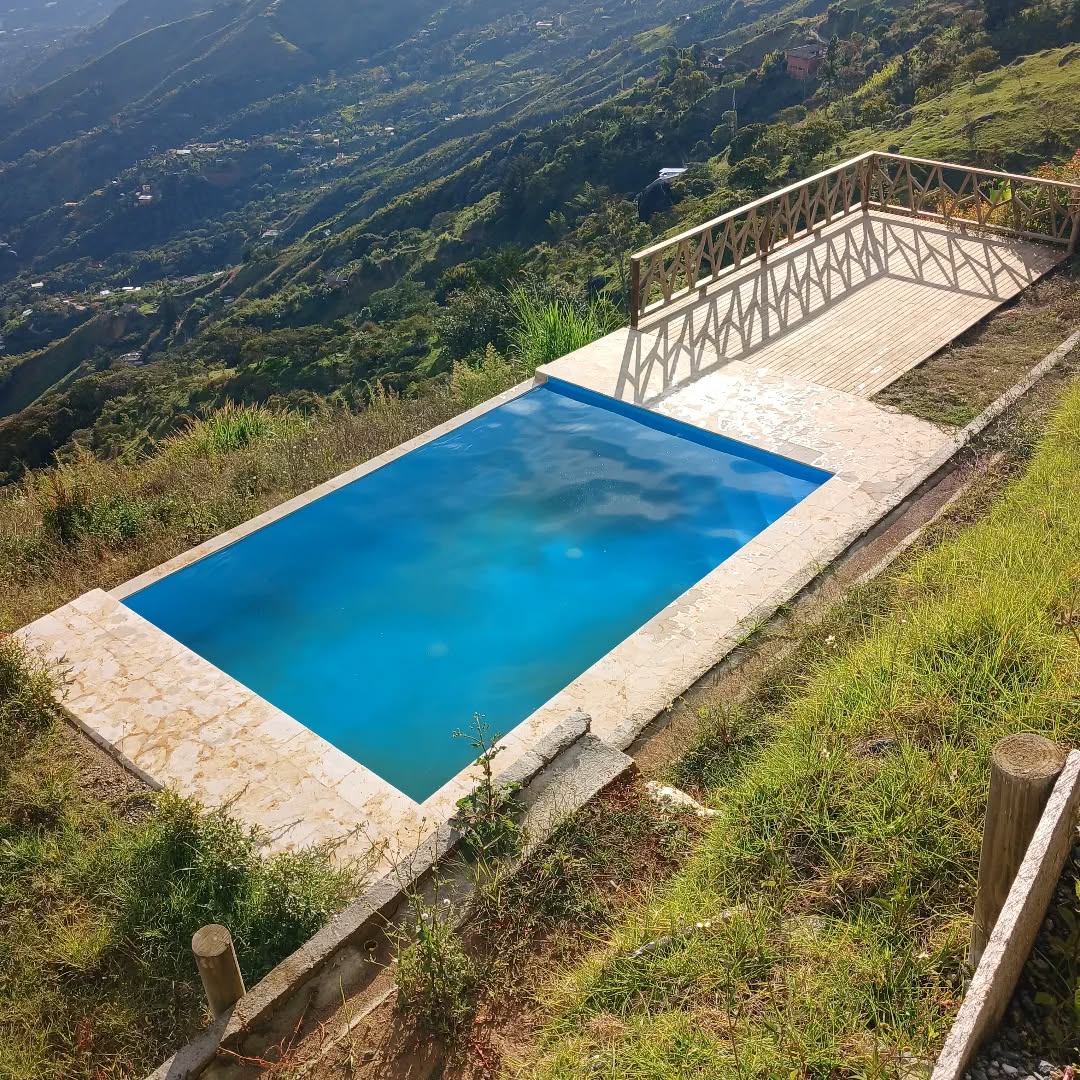 Piscina con deck mirador en madera sobre la montaña